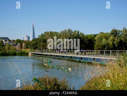 10 September 2015: Walworth, South London: The lake, Burgess Park boardwalk with The Shard and the city of London Stock Photo