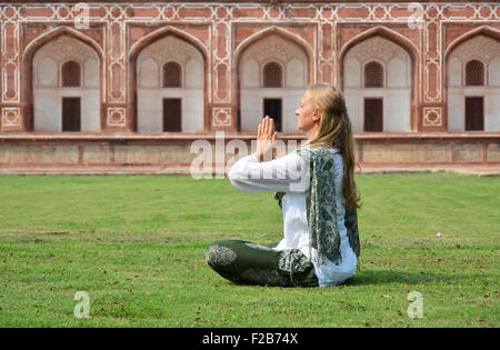 Young woman meditating in the yard of Humayun's Tomb. Delhi, India Stock Photo