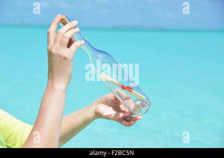 Bottle with a message in the hands Stock Photo