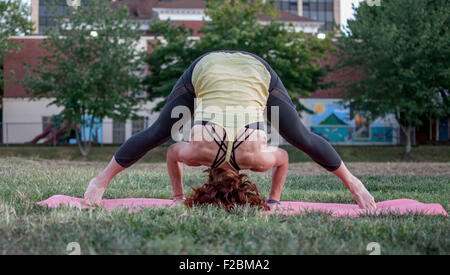Attractive young woman practicing yoga in the park Stock Photo