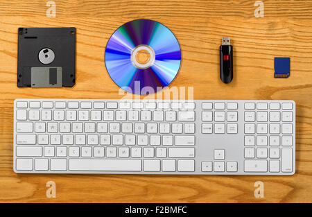 Top view of desktop with keyboard, diskette, CD, thumb drive, and Flash disk. Concept of portable data storage device Stock Photo