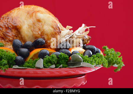 Red and white theme Thanksgiving Table setting with Roast Turkey Chicken on large platter centerpiece. Stock Photo