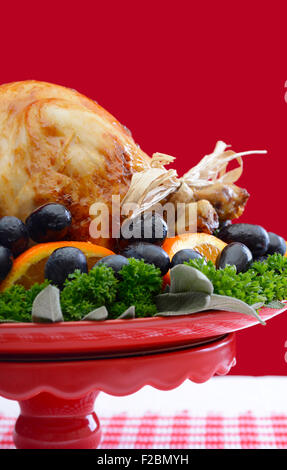 Red and white theme Thanksgiving Table setting with Roast Turkey Chicken on large platter centerpiece. Stock Photo