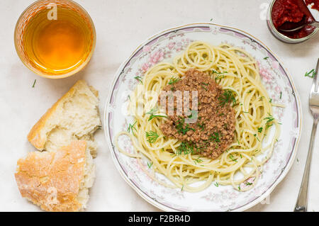 Spaghetti bolognese pasta in a dish and white wine glass Stock Photo