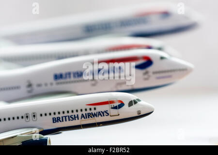 Row of British Airways planes with wavy red white and blue union jack pattern and BA logo. 1/200 metal scale models against plain white background. Stock Photo