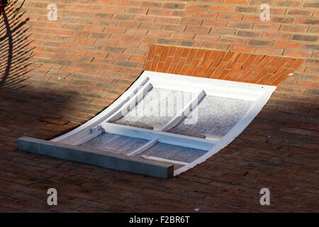 "From the knees of my nose to the belly of my toes", artwork by Alex Chinneck. White window curved set in brick wall but on ground. Stock Photo