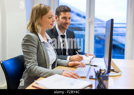 sharing business colleagues using computer in office Stock Photo