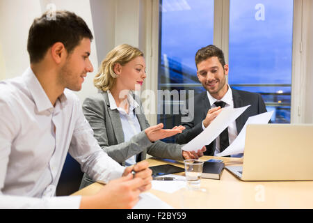 Businessmen and women arguing across boardroom table Stock Photo