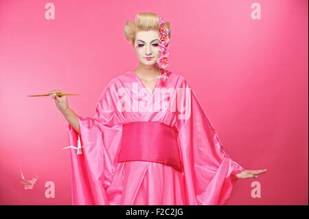 Beautiful geisha with an origami birds Stock Photo