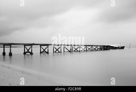 Black and white of pier on a cloudy day Stock Photo