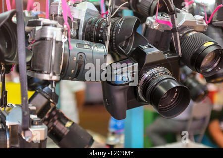 Old cameras hanging up for sale at an outdoor market in Hong Kong Stock Photo