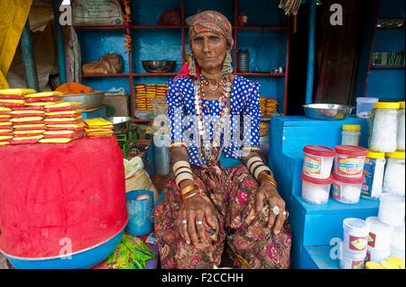 Woman belonging to the Lambani caste. She is in her shop; she sells paraphernalia to the devotees going to the nearby temple. Stock Photo