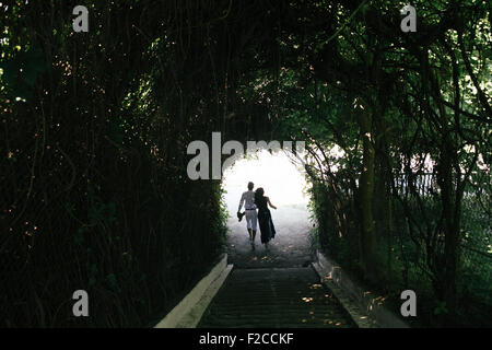 couple walking through the tunnel of trees Stock Photo