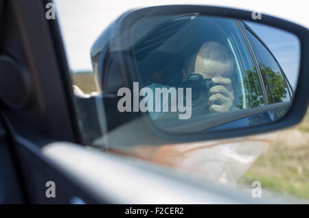 Reflection of Photographer Taking Picture in Car Side Mirror Stock Photo
