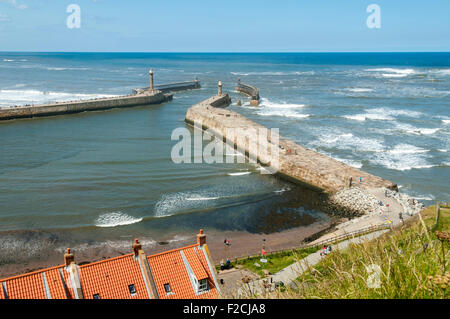 The piers of Whitby Harbour with Sandsend Bay beyond. From the Haggerlythe cliff, Whitby, Yorkshire, England, UK Stock Photo