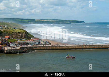 The west pier of Whitby Harbour with Sandsend Bay beyond. From the Haggerlythe cliff, Whitby, Yorkshire, England, UK Stock Photo