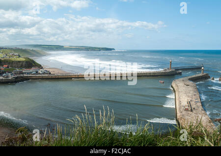 The piers of Whitby Harbour with Sandsend Bay beyond. From the Haggerlythe cliff, Whitby, Yorkshire, England, UK Stock Photo