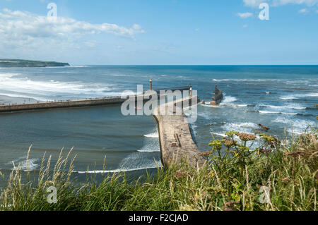 The piers of Whitby Harbour with Sandsend Bay beyond. From the Haggerlythe cliff, Whitby, Yorkshire, England, UK Stock Photo