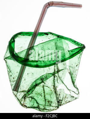 flattened, dirty green translucent plastic cup with bent straw Stock Photo