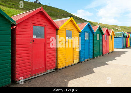 Multi-coloured beach huts at Whitby Beach, Whitby, Yorkshire, England, UK Stock Photo