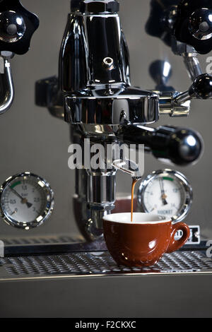 Stainless espresso machine in action with brown espresso cup Stock Photo