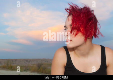 An attractive young woman posing with thoughtful, serious and silly expressions outdoors against a blue sky. Stock Photo