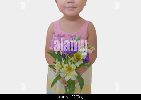 3 year old girl holding flowers. Photographed in Aug 2015. Stock Photo