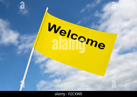 Yellow flag welcome in front of a blue sky Stock Photo