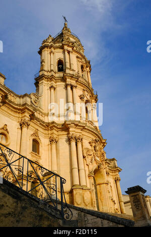 Low angle view of the Duomo di San Giorgio cathedral tower against a sunny blue sky in Modica, south eastern Sicily, Italy. Stock Photo