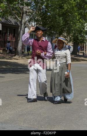 Reenactors walking arm in arm down Duke of Gloucester Street  Colonial Williamsburg living-history museum Virginia Stock Photo
