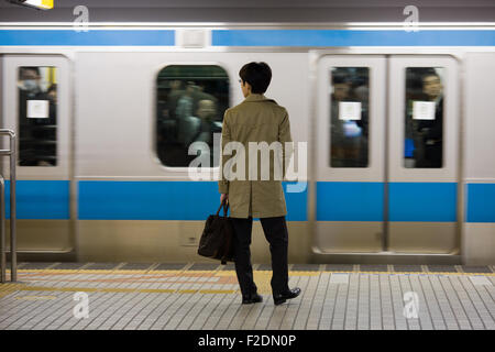 Man alone standing on subway platform train in motion Stock Photo