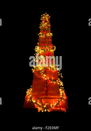 Stack of many christmas presents illuminated like a christmas tree Stock Photo