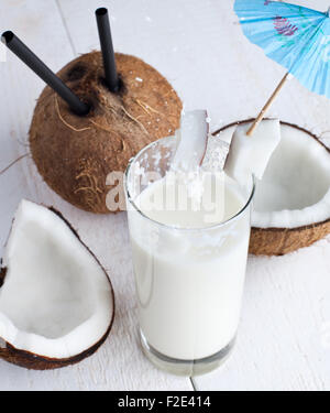 Spalsh drink with milk and coconut on white wooden table. Stock Photo