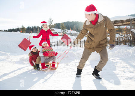 Happy family carrying Christmas Presents with sled Stock Photo