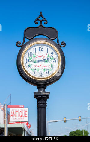 A outdoor large wrought iron clock on a pole advertising an Antique shop in Bethany, Oklahoma, USA on route 66. Stock Photo