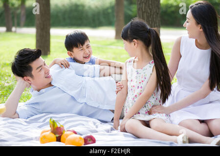 Happy young family having picnic on grass Stock Photo