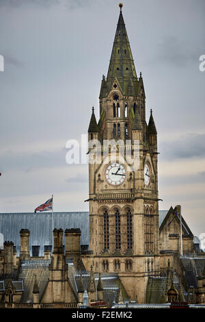 Manchester Town hall clock tower close up over the rooftops clock face union flag flying upright copyspace upright   Manchester Stock Photo