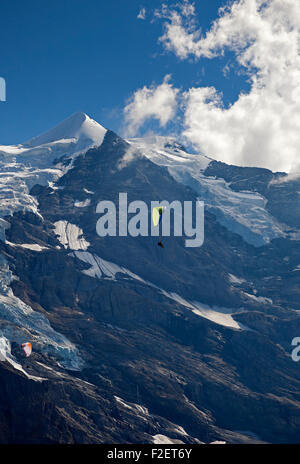 Paragliding in Swiss Alps with snow covered peak in background between Jungfrau and Breithorn Switzerland  Europe Stock Photo