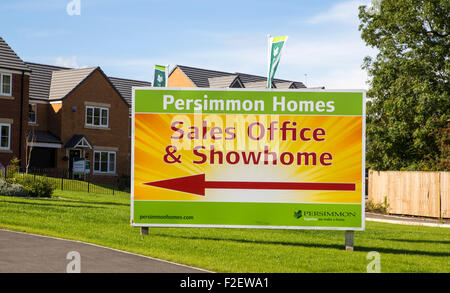 persimmon homes. Large sign in front of new houses on large new housing development with directions to the sales office and showhome Stock Photo