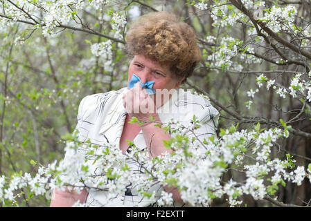 Woman with allergic rhinitis in the spring garden Stock Photo