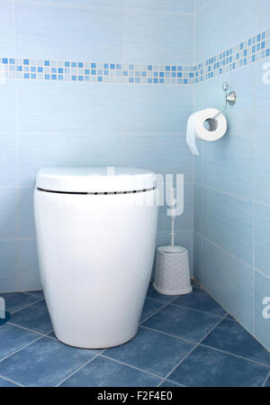 Modern white toilet bowl in blue bathroom Stock Photo