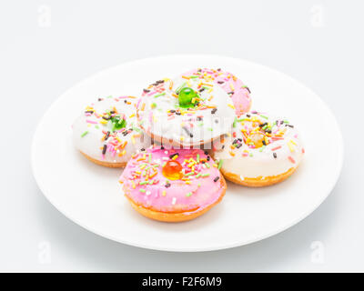 Fresh homemade colorful donuts with icing glaze delicious on white plate Stock Photo
