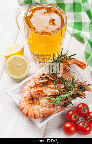 Beer mug and grilled shrimps on wooden table Stock Photo