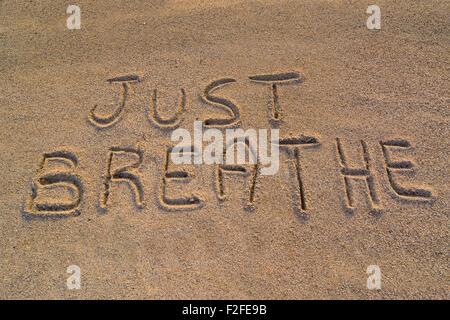 In the picture the words on the sand 'Just breathe'. Stock Photo