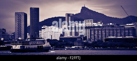 Skyline of Rio de Janeiro city with ship sailing in foreground, blue toned image. Stock Photo