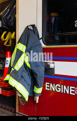 Fireman's jacket hanging on the fire truck door ready for an emergency call Stock Photo