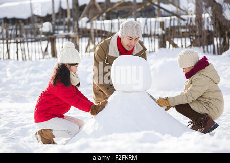 Download Two young boys building snowman Stock Photo: 21399231 - Alamy