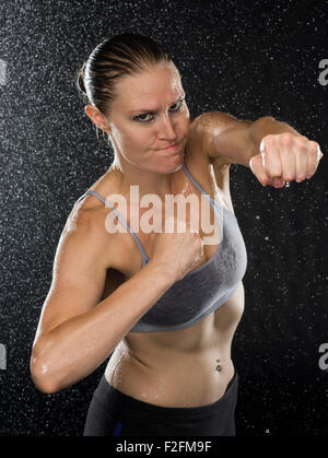 Female Fighter in Punching Pose Looking Aggressive Stock Photo