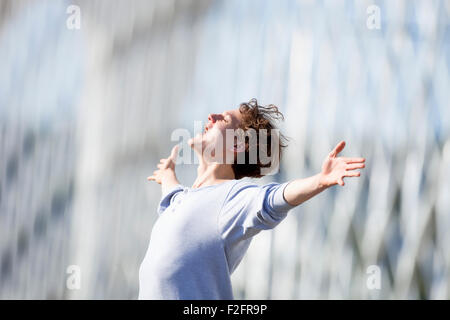 Excited Young Man Stretching out his Arm in Emotion Outdoors Stock Photo
