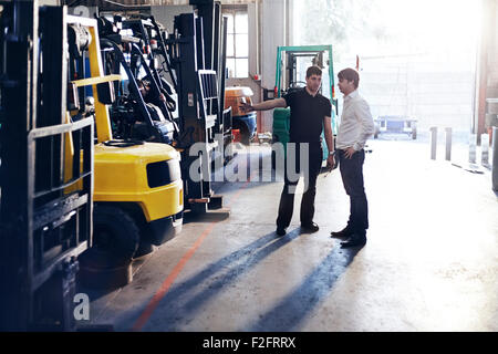 Mechanic and customer talking in auto repair shop Stock Photo